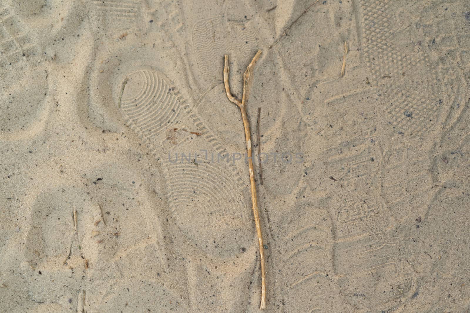 Sand on the beach with footprints and shoes. Many footprints with shoes and without shoes.