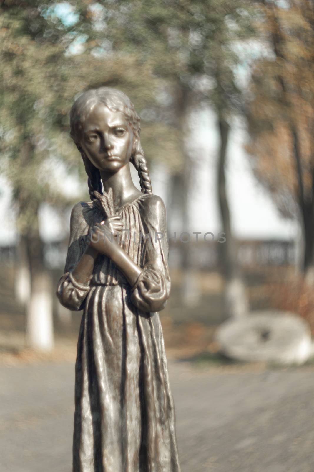 Statue of a very thin hungry girl. Monument to Holocost. Blurred background and soft focus on monument. Symbol of hungry years.