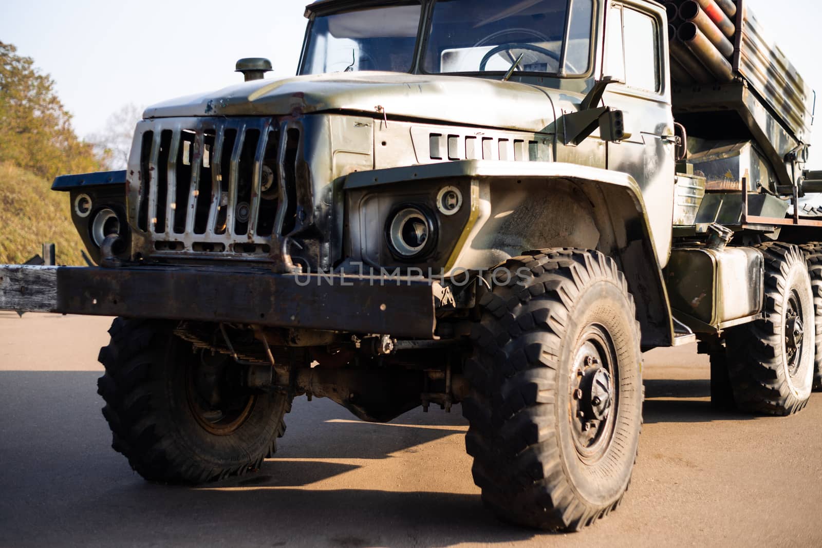 Camouflage military truck with rocket launcher. Outdoor military vehicles museum. Armor is damaged at the battlefield.