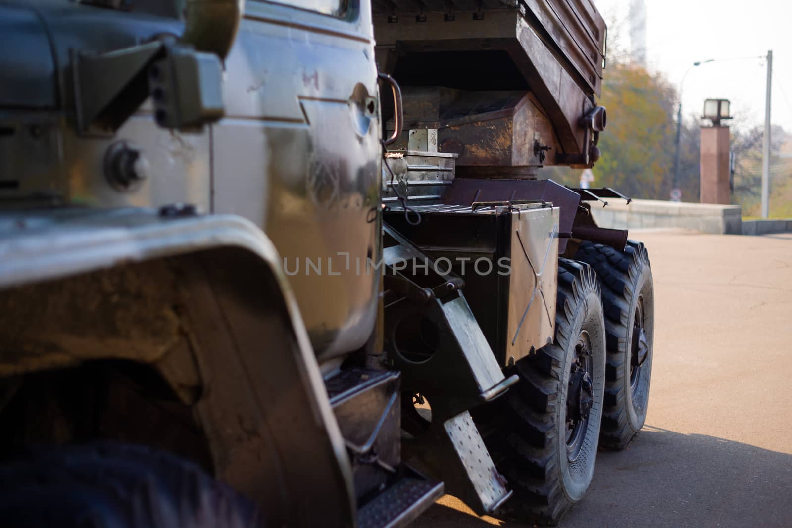 Camouflage military truck with rocket launcher. Outdoor military vehicles museum. Armor is damaged at the battlefield.