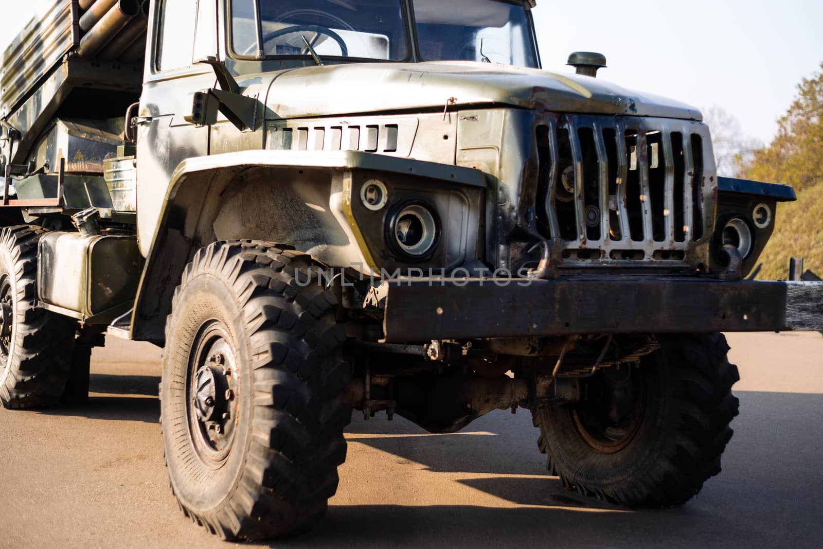 Camouflage military truck with rocket launcher. Outdoor military vehicles museum. Armor is damaged at the battlefield. by alexsdriver