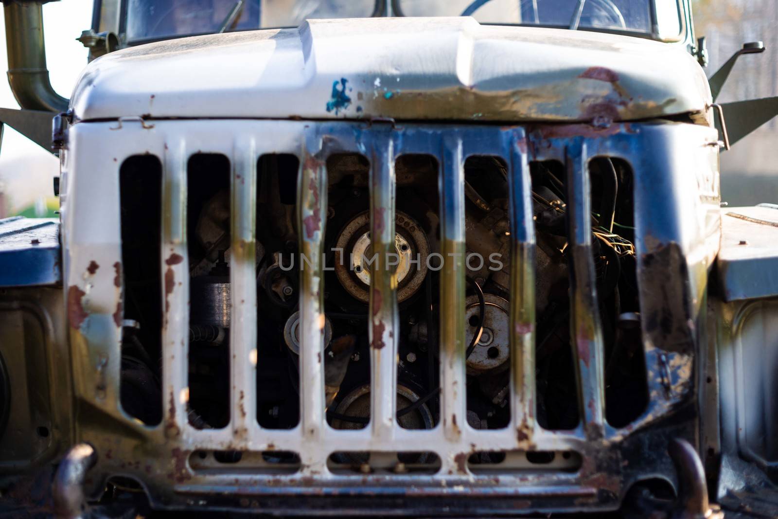 Camouflage military truck with rocket launcher. Engine under hood close up view. Outdoor military vehicles museum. Armor is damaged at the battlefield. by alexsdriver