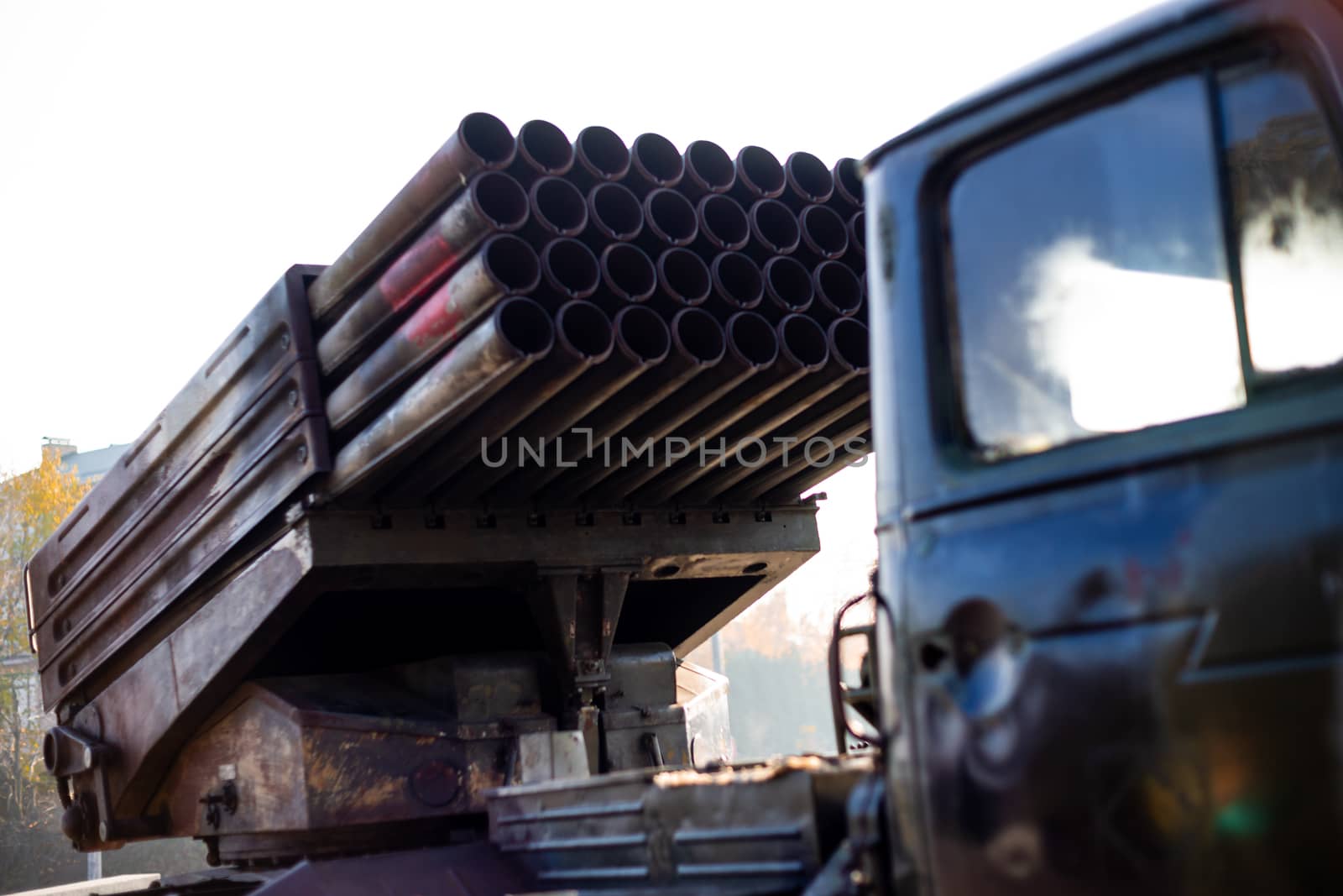 Camouflage military truck with rocket launcher. Outdoor military vehicles museum. Armor is damaged at the battlefield.