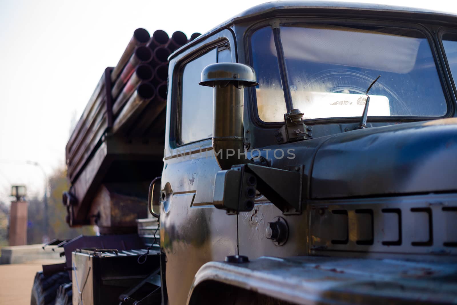 Camouflage military truck with rocket launcher. Outdoor military vehicles museum. Armor is damaged at the battlefield.