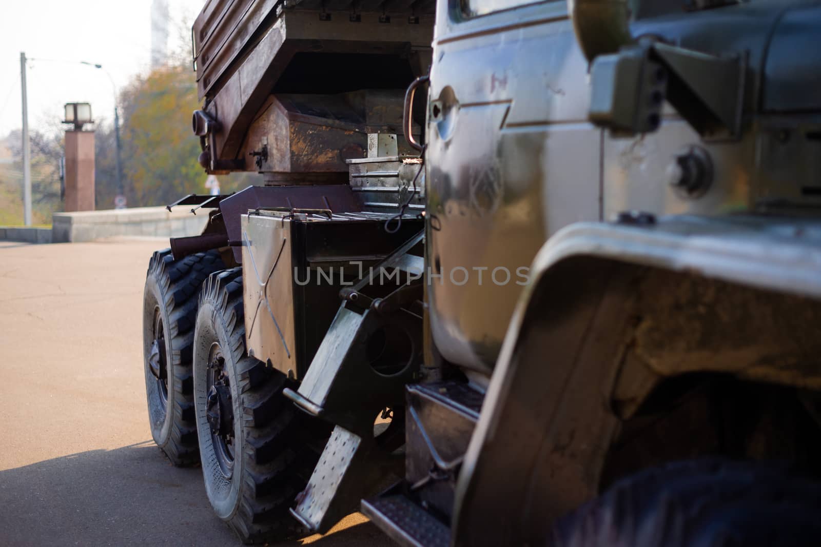 Camouflage military truck with rocket launcher. Outdoor military vehicles museum. Armor is damaged at the battlefield.