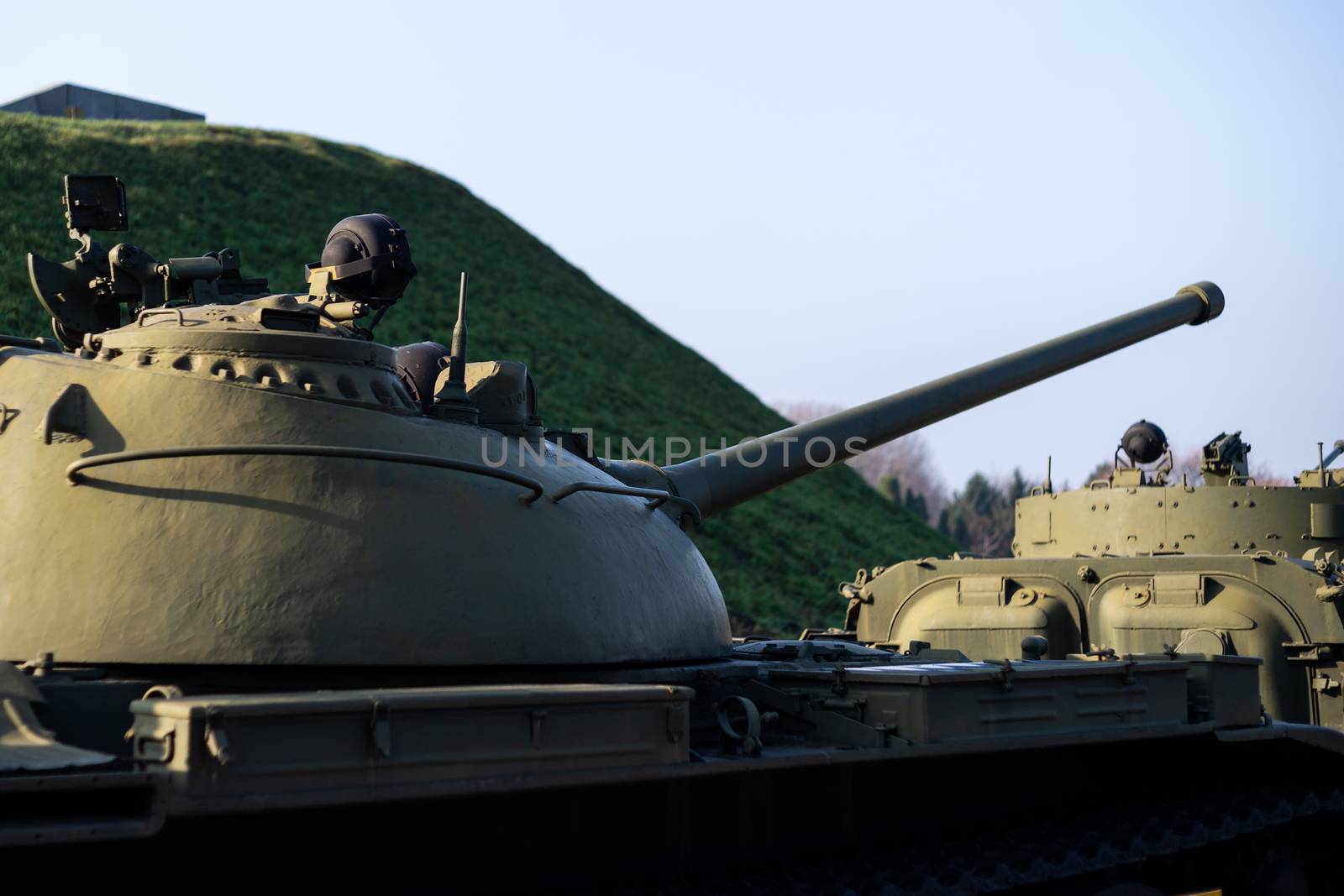 Parts of the hull of the armored old tank. In front and back of tank stays many different tanks. Parts closeup. Military equipment outdoor open air museum.