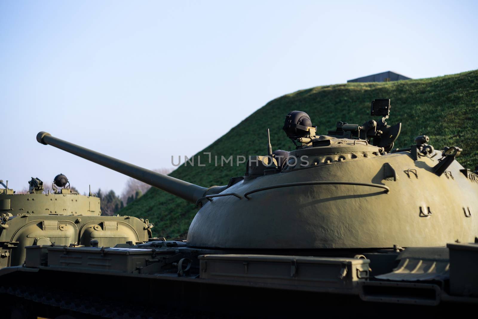 Parts of the hull of the armored old tank. In front and back of tank stays many different tanks. Parts closeup. Military equipment outdoor open air museum.