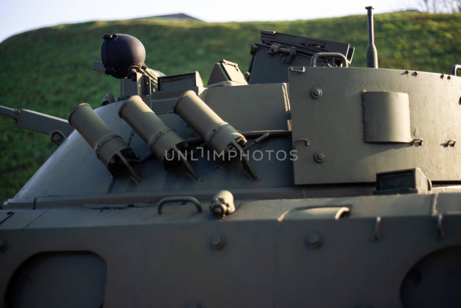 Parts of the hull of the armored infantry vehicle. In front and back of vehicle stays many different armored military vehicles. Military equipment outdoor open air museum.