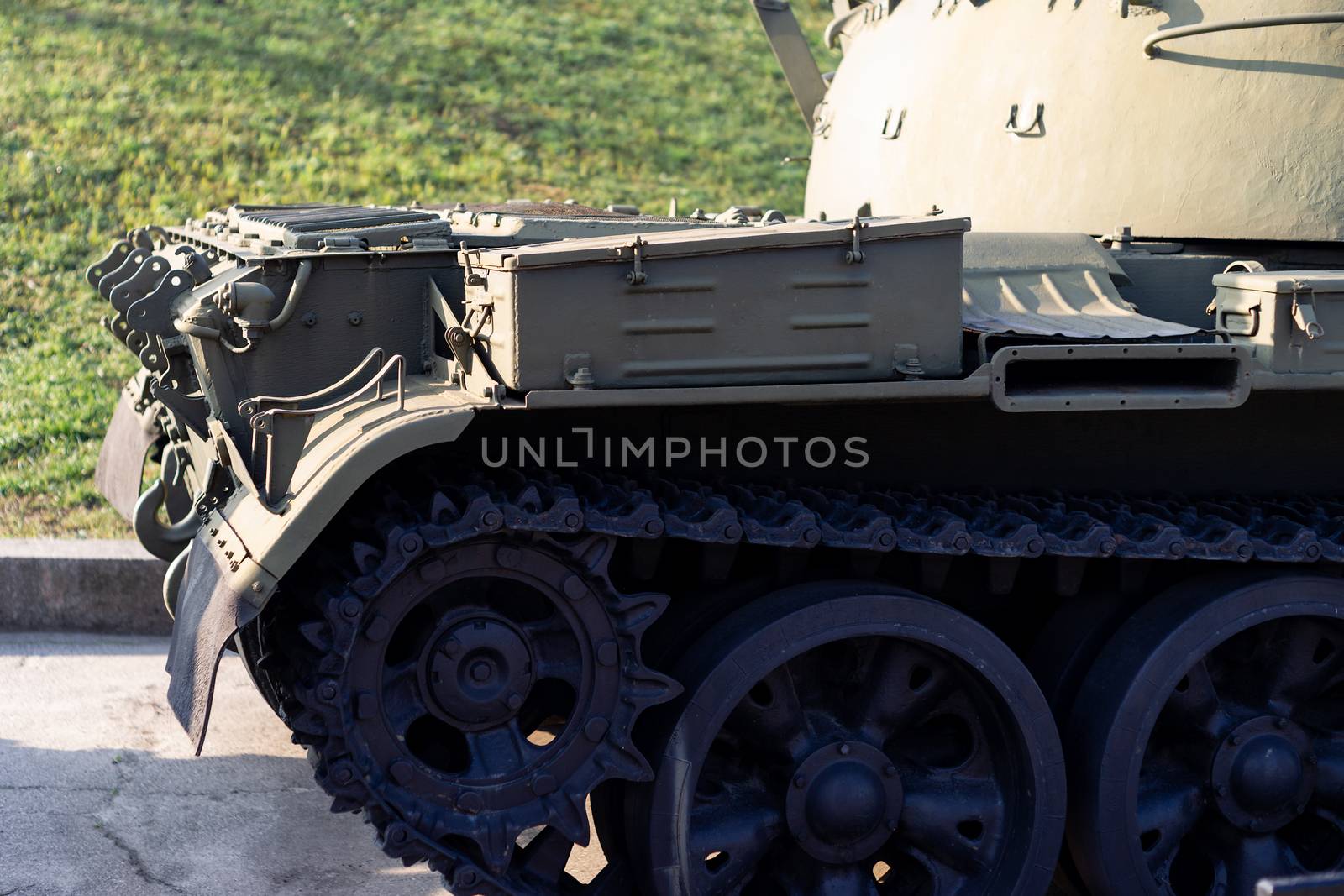 Parts of the hull of the armored old tank. In front and back of tank stays many different tanks. Parts closeup. Military equipment outdoor open air museum. by alexsdriver