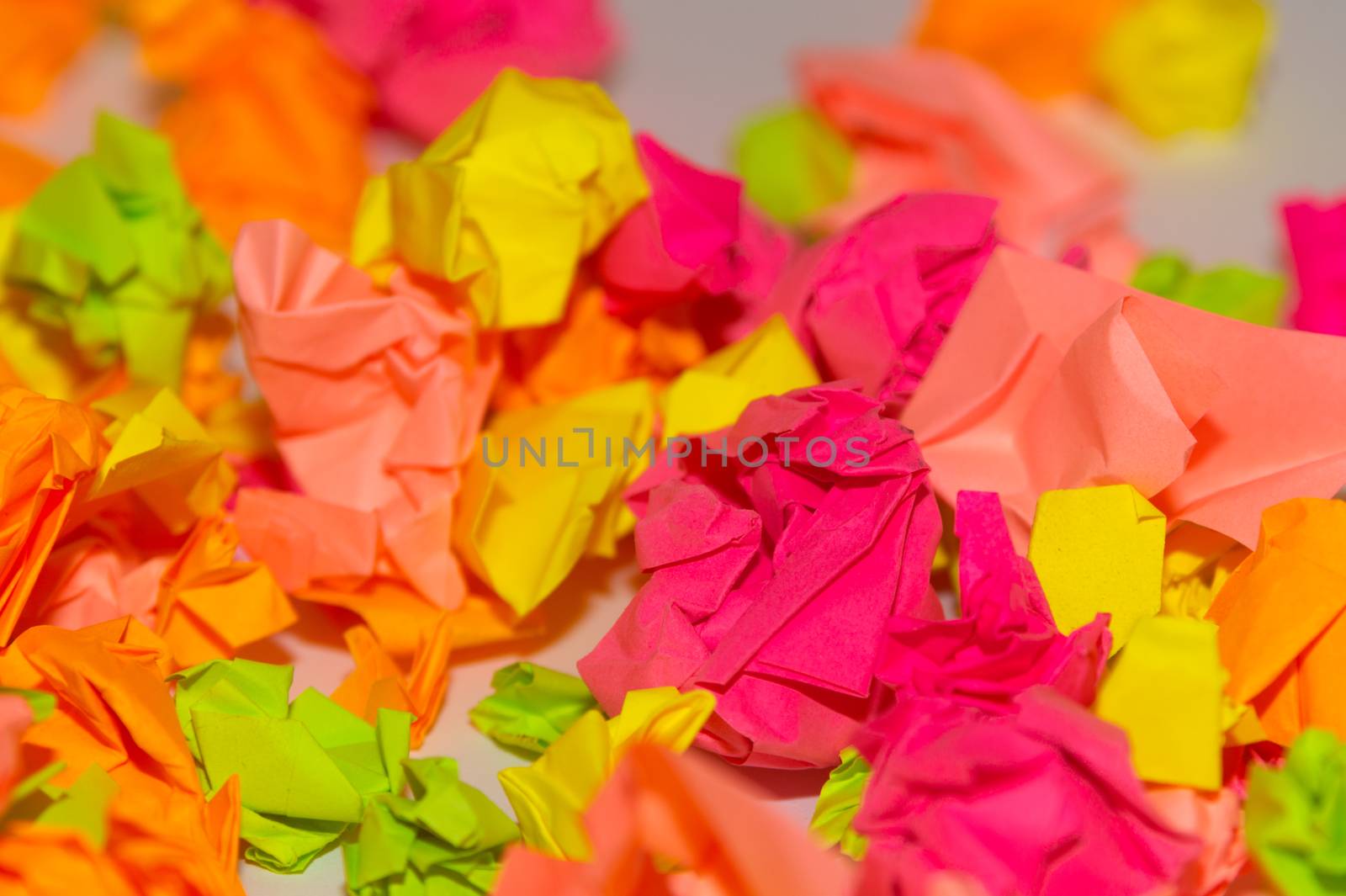 Bright crumpled multi-colored stickers on the office white board.