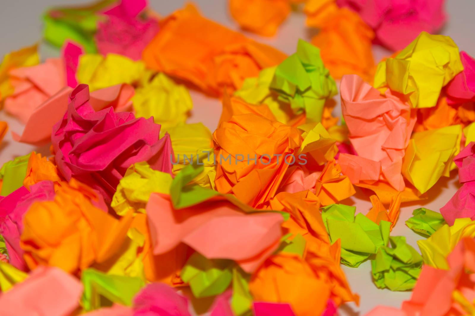 Bright crumpled multi-colored stickers on the office white board.