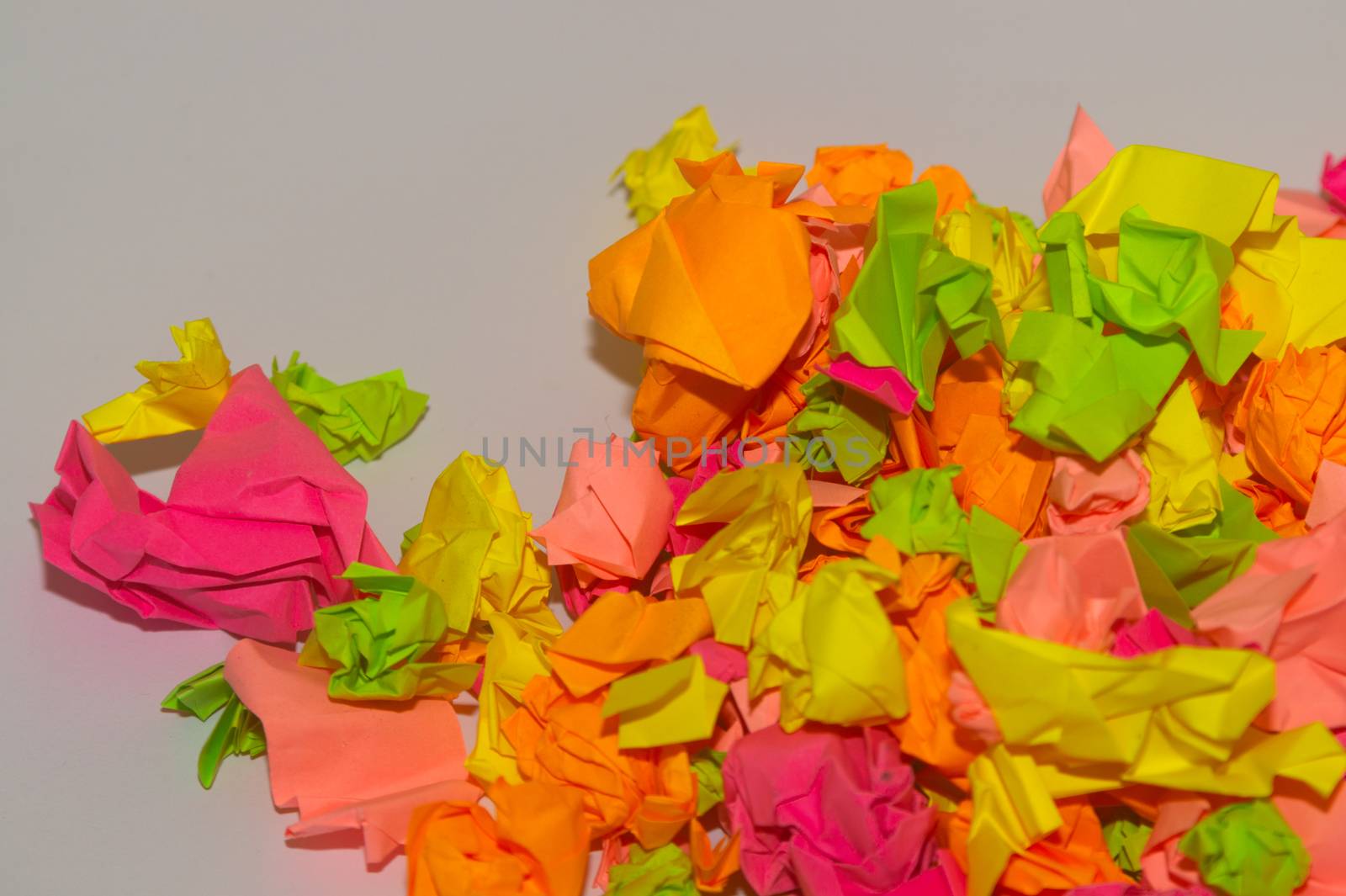 Bright crumpled multi-colored stickers on the office white board.