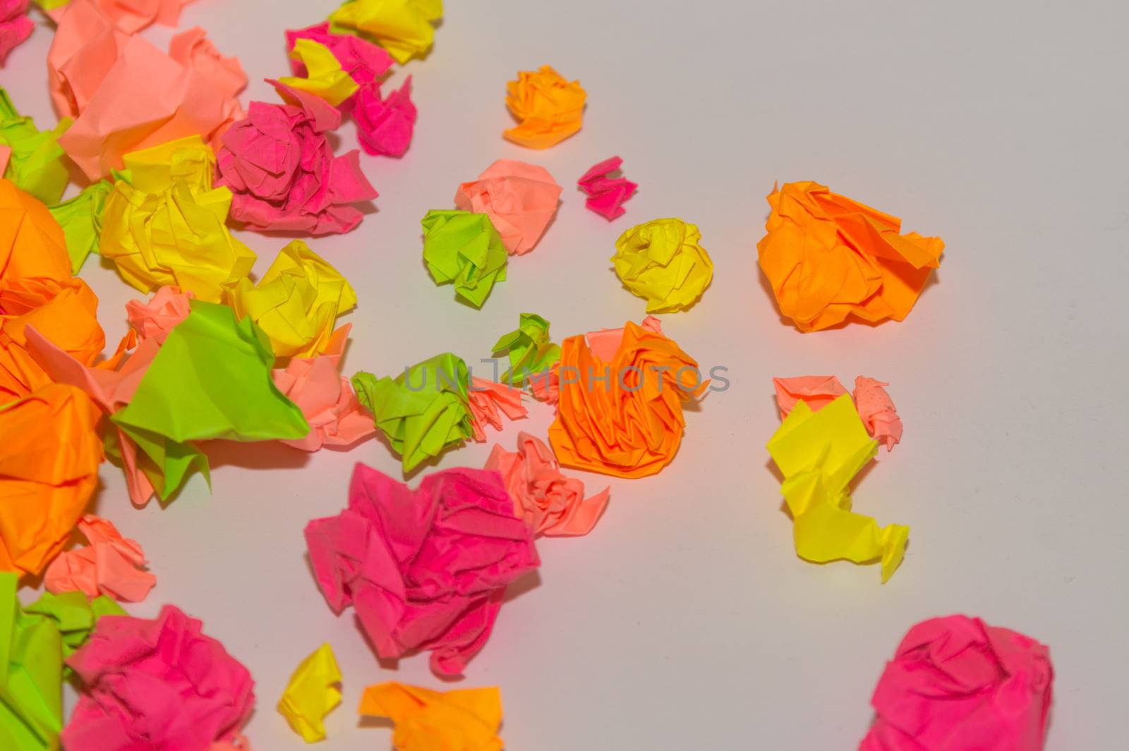 Bright crumpled multi-colored stickers on the office white board.