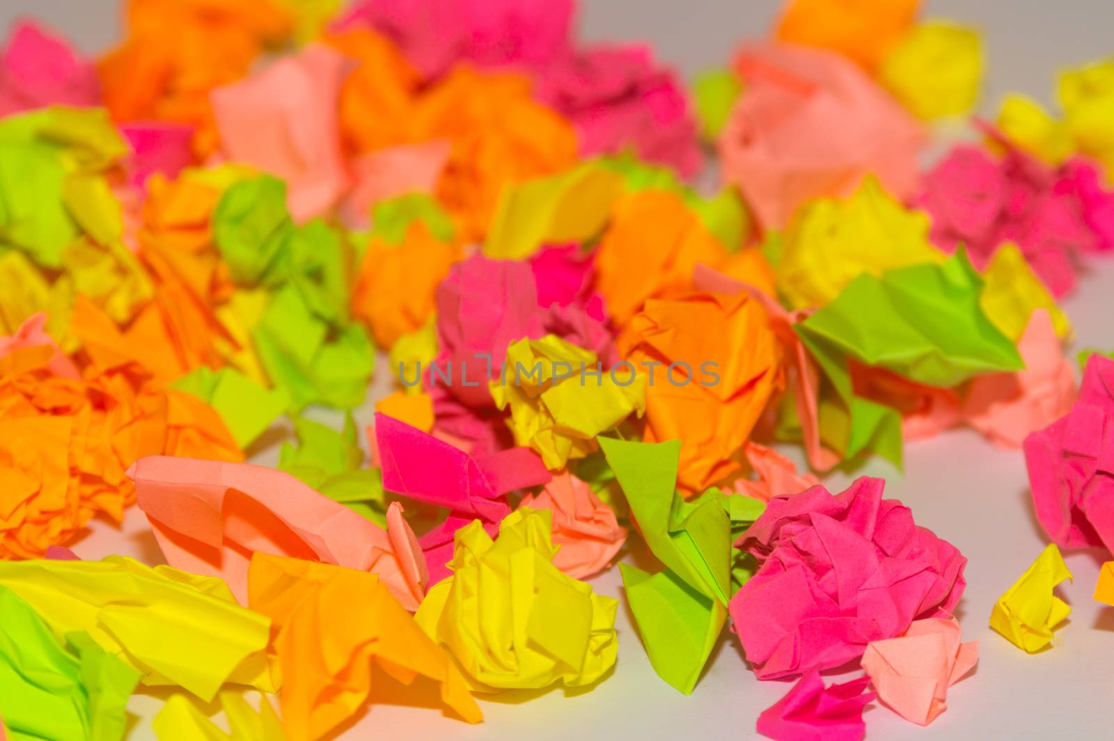 Bright crumpled multi-colored stickers on the office white board.