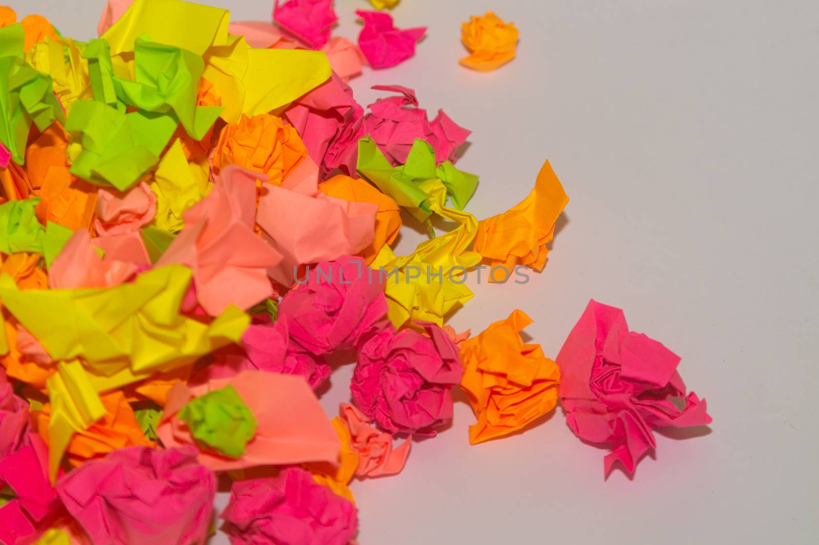 Bright crumpled multi-colored stickers on the office white board.