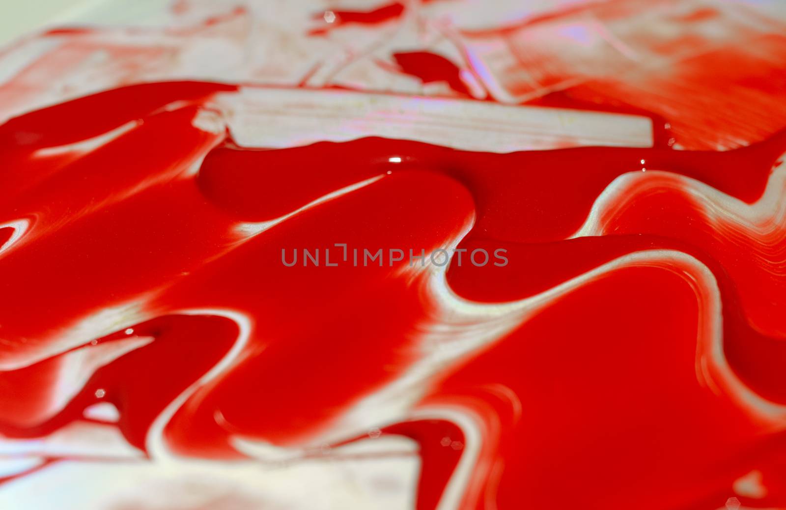 Hue red acrylic paint on glare table. Palette on table. Artist life.