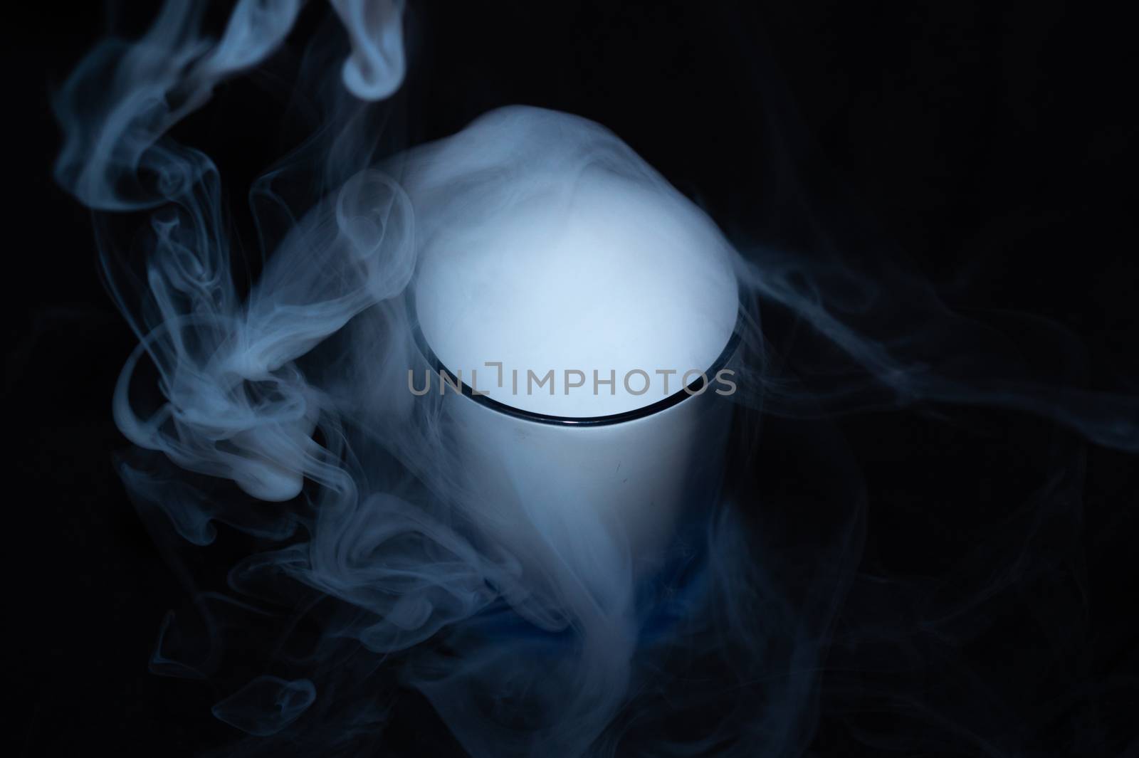 White smoke on black fabric background in glass. Smoke spreads over the background. Vaping culture, life without cigarettes. Conceptual image.