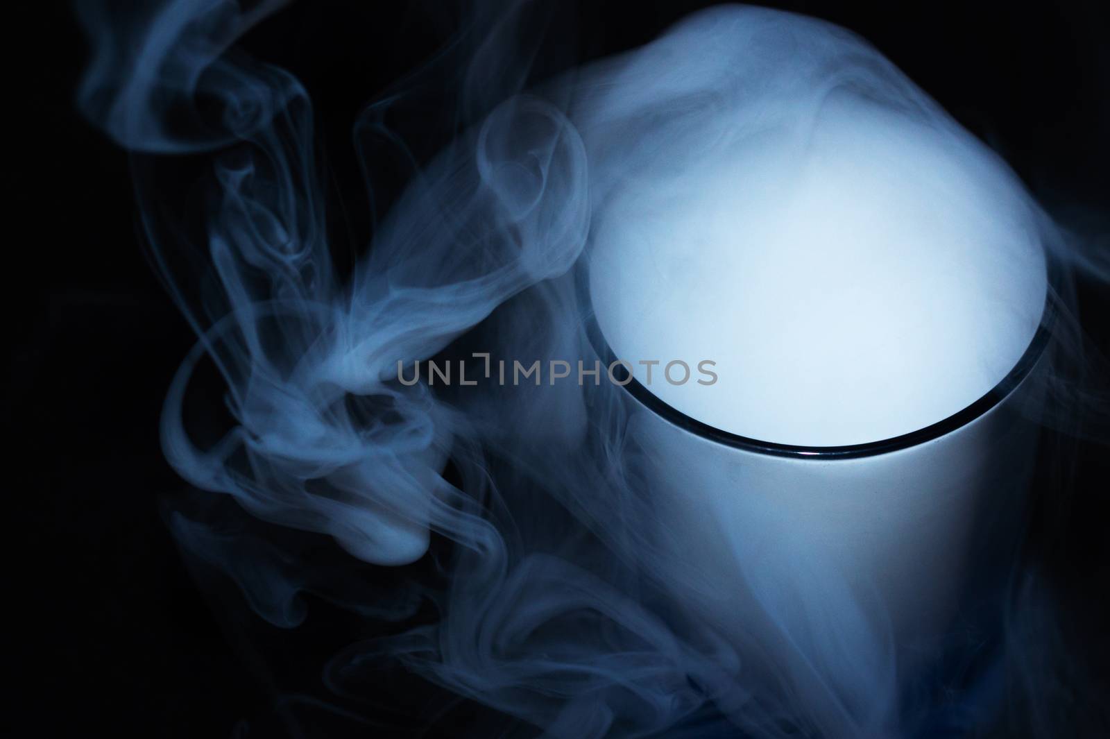 White smoke on black fabric background in glass. Smoke spreads over the background. Vaping culture, life without cigarettes. Conceptual image.