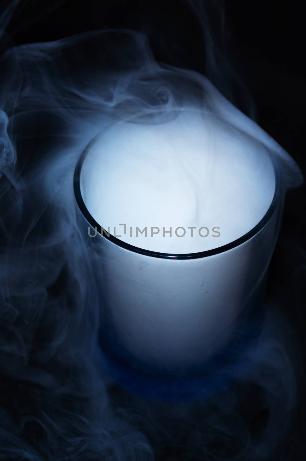 White smoke on black fabric background in glass. Smoke spreads over the background. Vaping culture, life without cigarettes. Conceptual image.