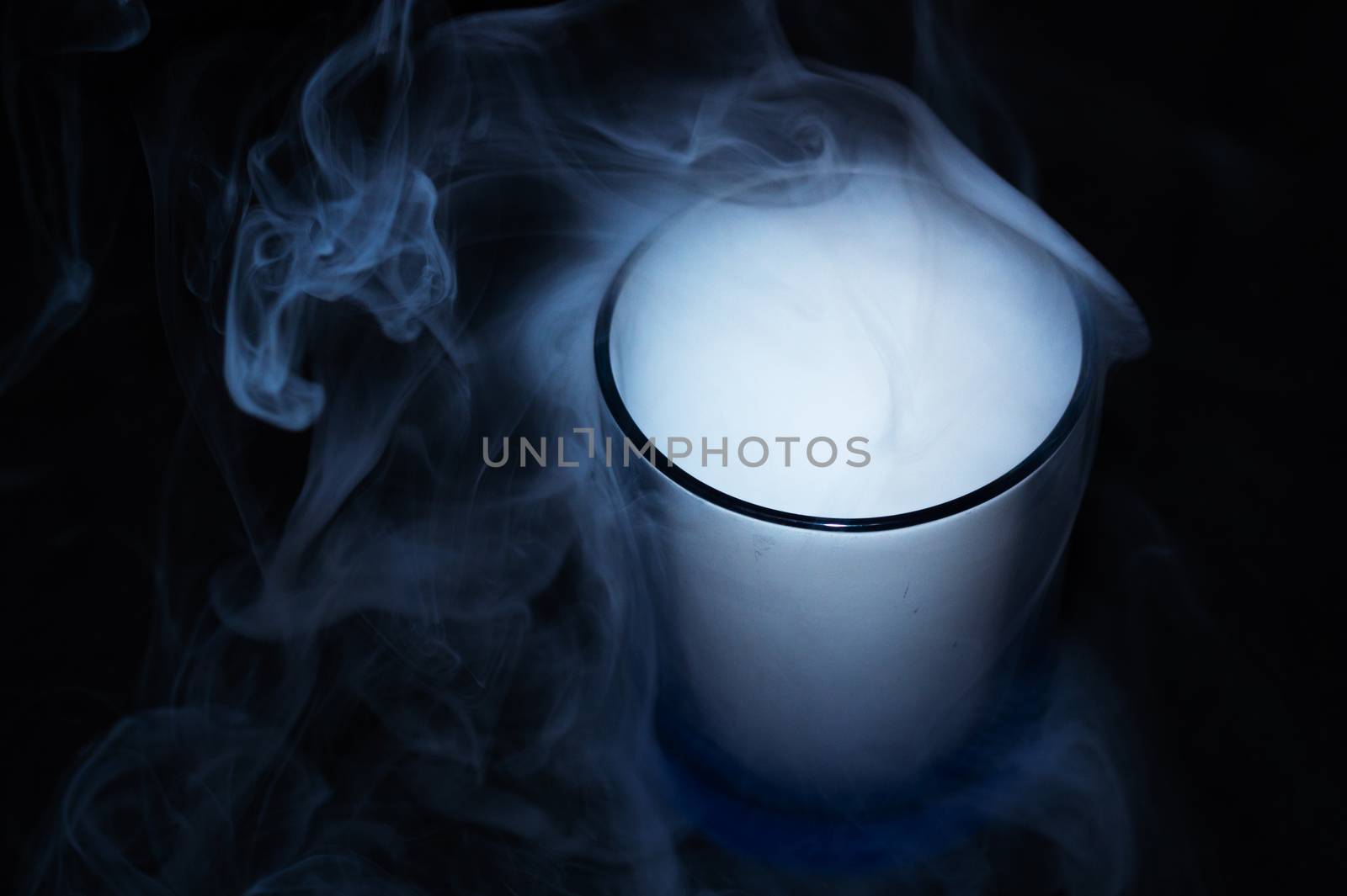 White smoke on black fabric background in glass. Smoke spreads over the background. Vaping culture, life without cigarettes. Conceptual image.