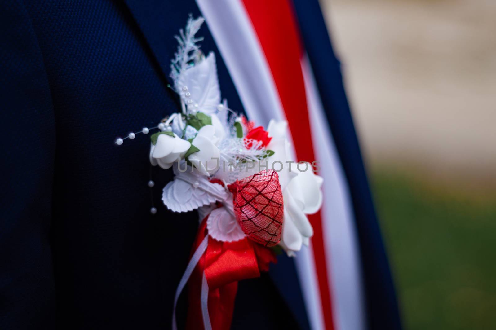 Groom's suit with a flower on his chest. Wedding details in close-up view.