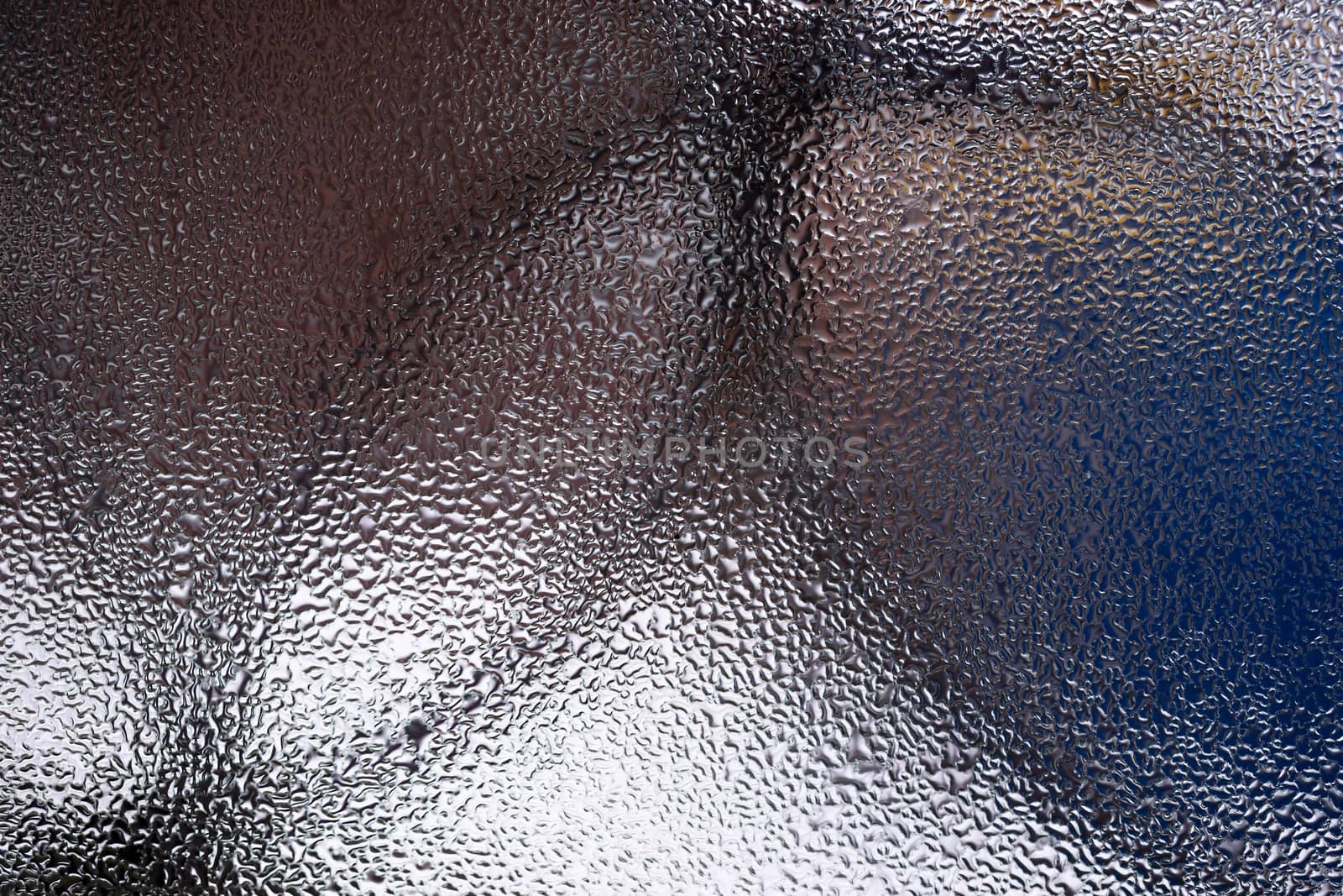 Water drops on glass window close up with blurred background. Drops in macro. Condensate on window closeup. Wet air.