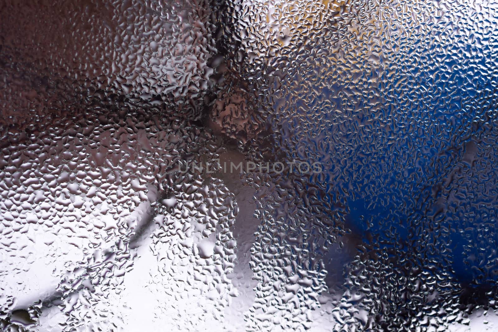 Water drops on glass window close up with blurred background. Drops in macro. Condensate on window closeup. Wet air.
