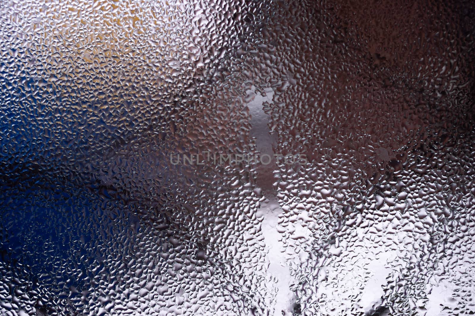 Water drops on glass window close up with blurred background. Drops in macro. Condensate on window closeup. Wet air.