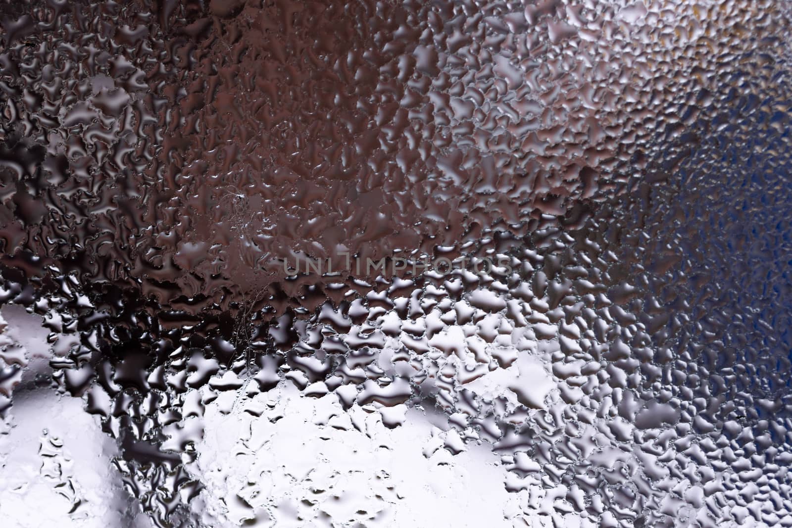 Water drops on glass window close up with blurred background. Drops in macro. Condensate on window closeup. Wet air.