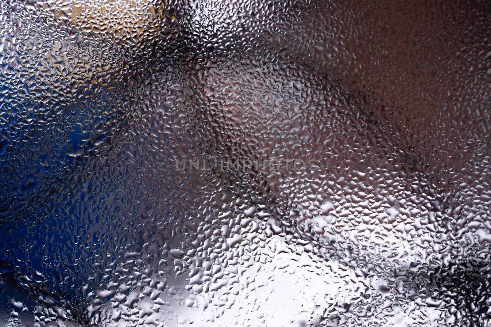 Water drops on glass window close up with blurred background. Drops in macro. Condensate on window closeup. Wet air.