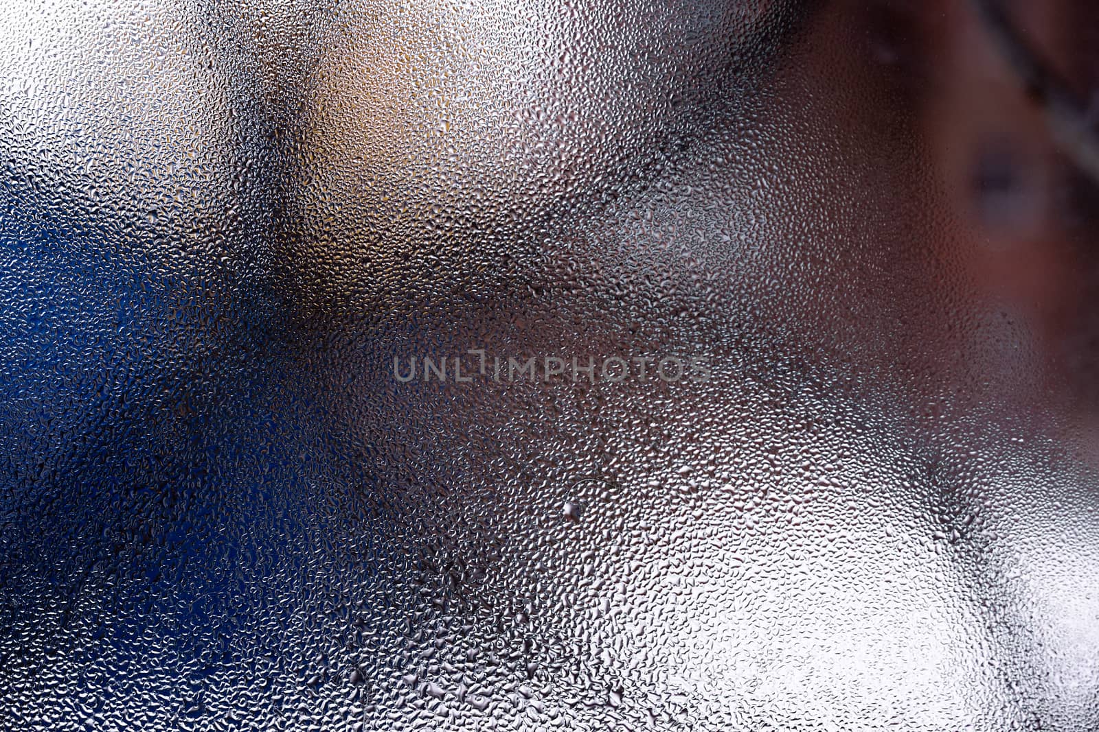 Water drops on glass window close up with blurred background. Drops in macro. Condensate on window closeup. Wet air.