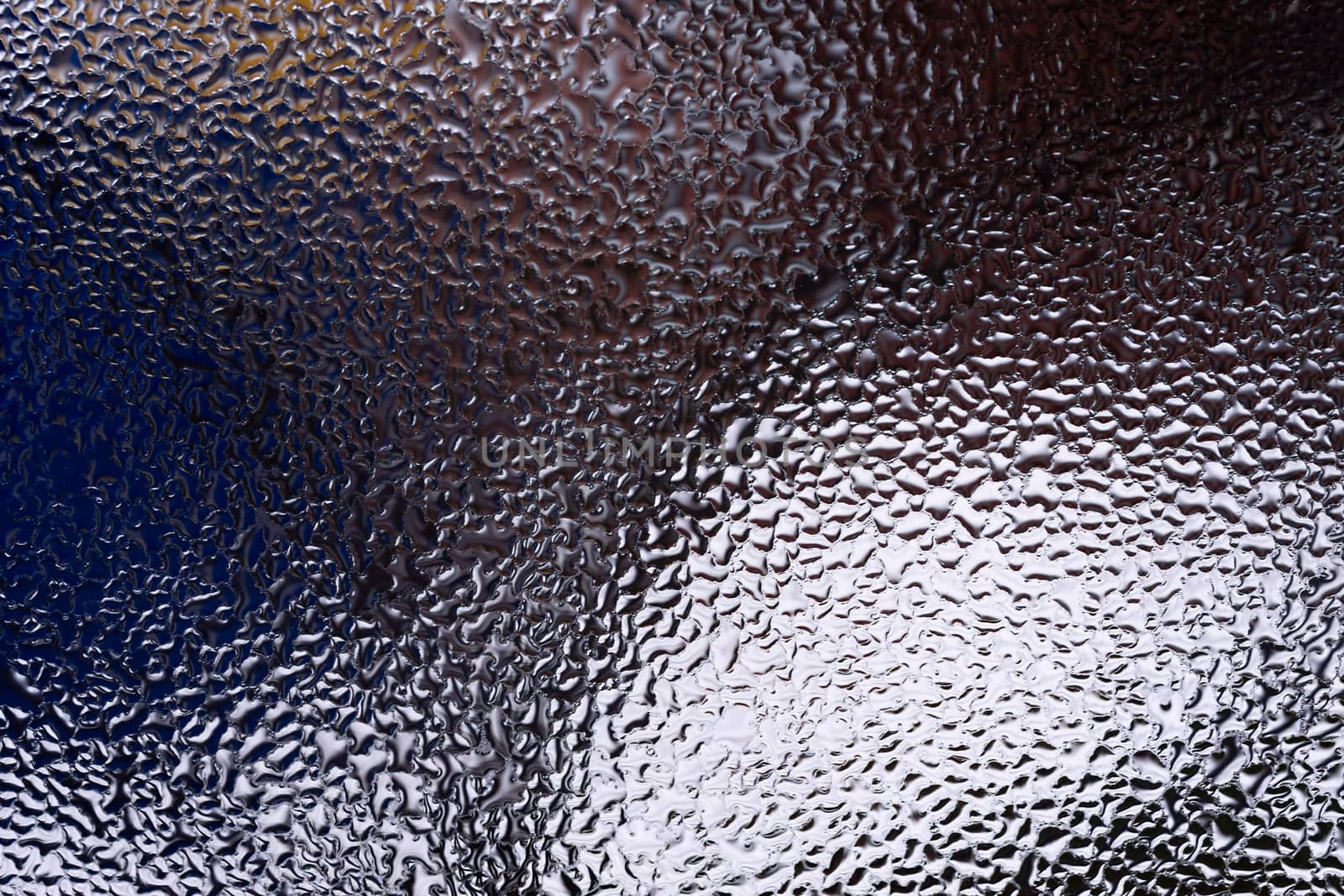 Water drops on glass window close up with blurred background. Drops in macro. Condensate on window closeup. Wet air.