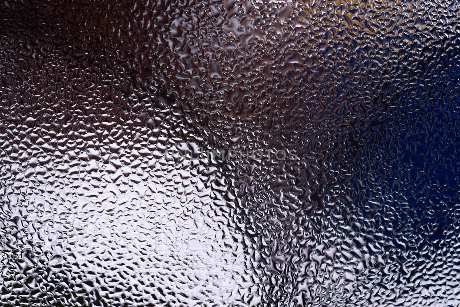 Water drops on glass window close up with blurred background. Drops in macro. Condensate on window closeup. Wet air.