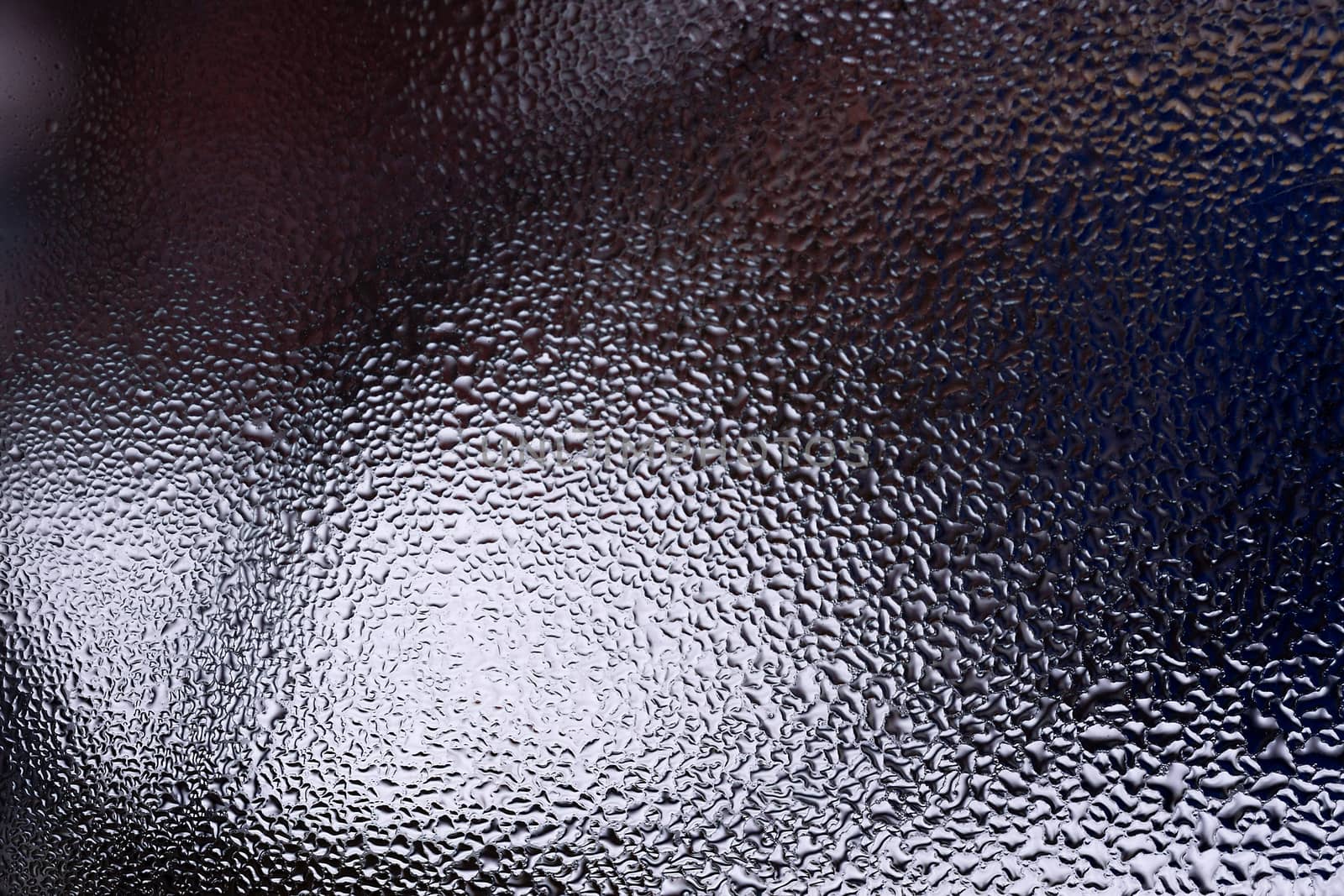 Water drops on glass window close up with blurred background. Drops in macro. Condensate on window closeup. Wet air.