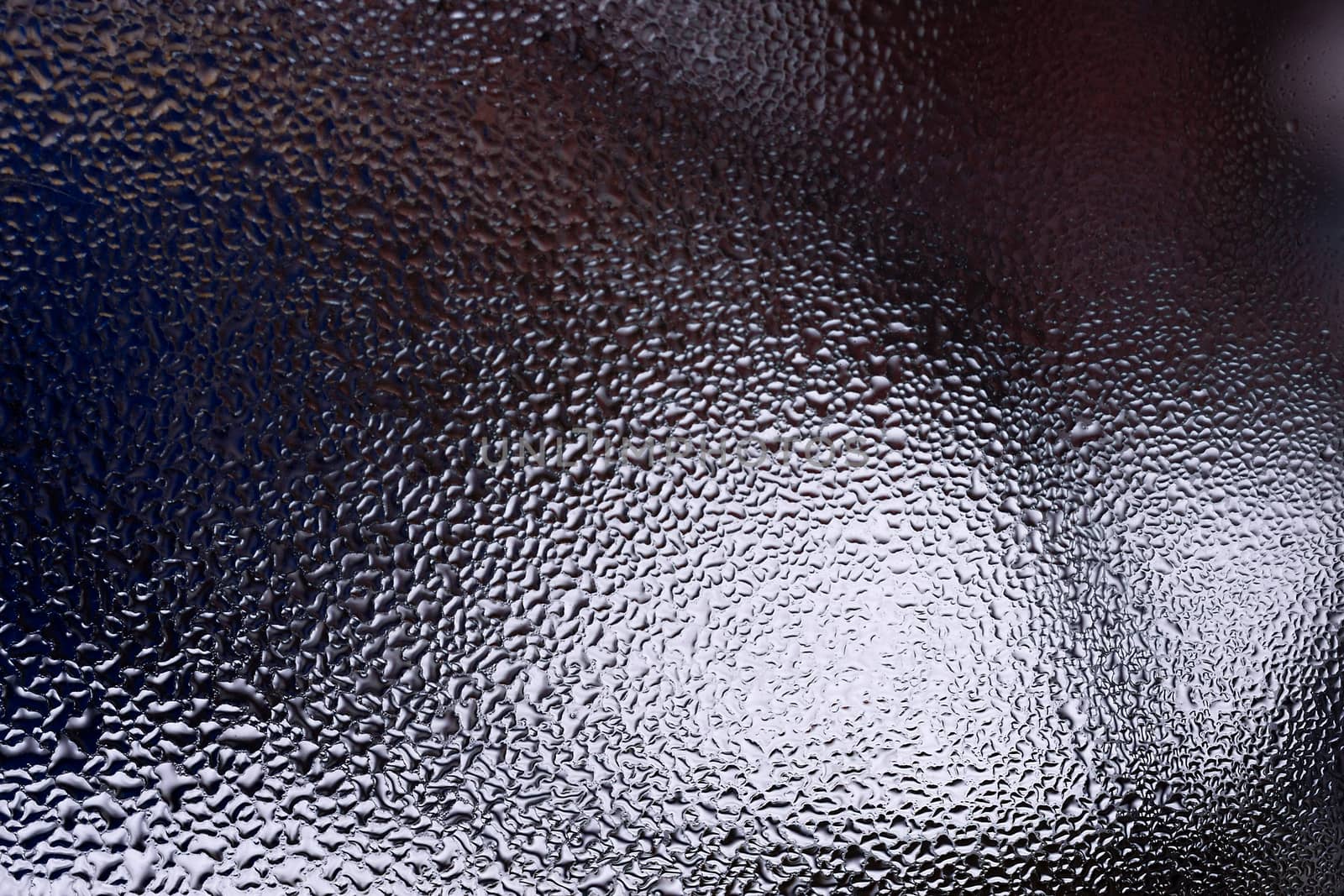 Water drops on glass window close up with blurred background. Drops in macro. Condensate on window closeup. Wet air.