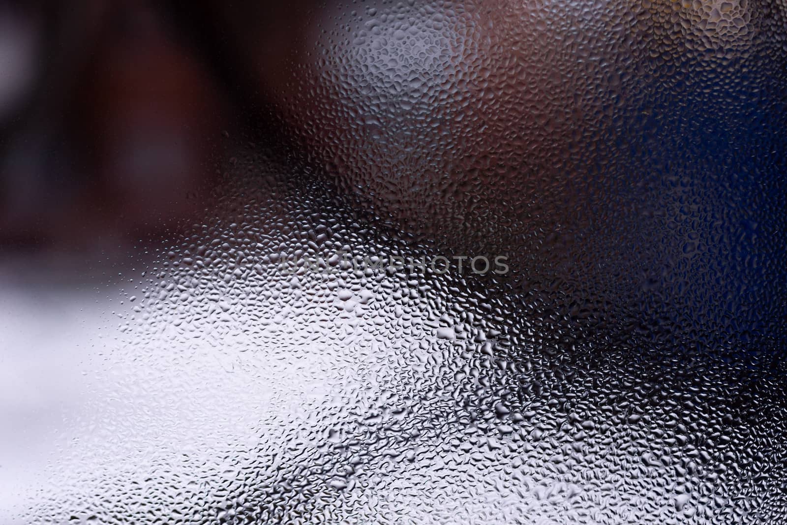 Water drops on glass window close up with blurred background. Drops in macro. Condensate on window closeup. Wet air.