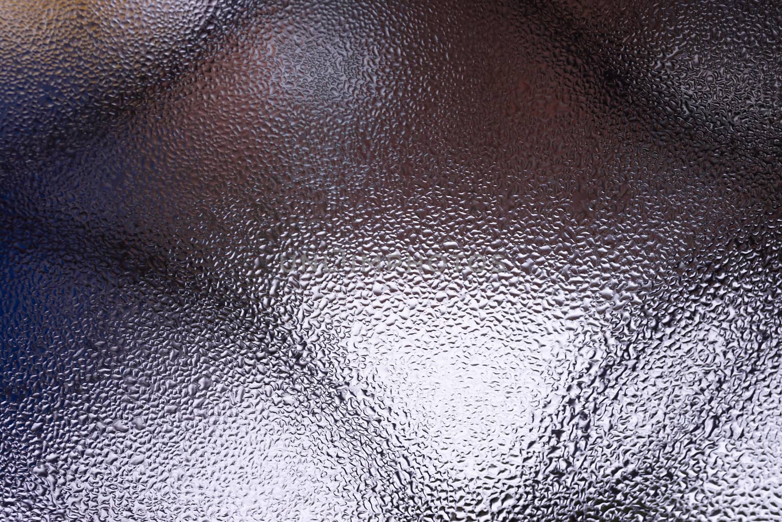 Water drops on glass window close up with blurred background. Drops in macro. Condensate on window closeup. Wet air.
