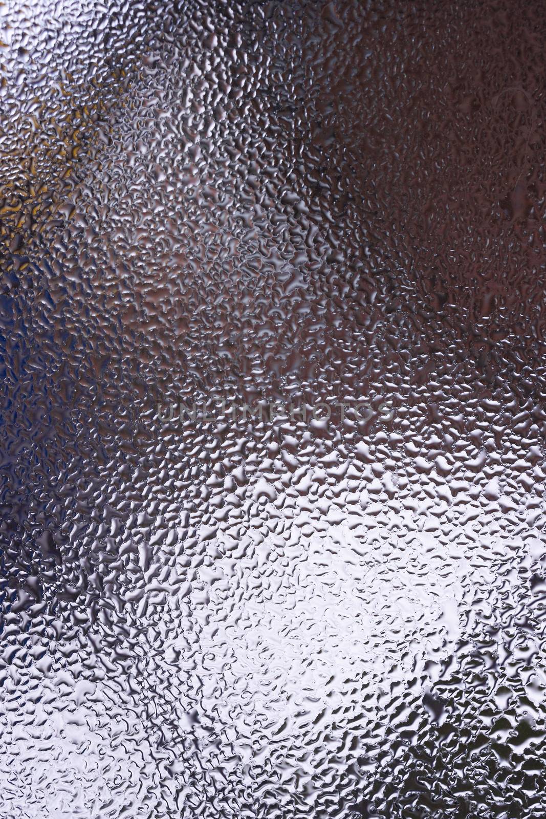 Water drops on glass window close up with blurred background. Drops in macro. Condensate on window closeup. Wet air.