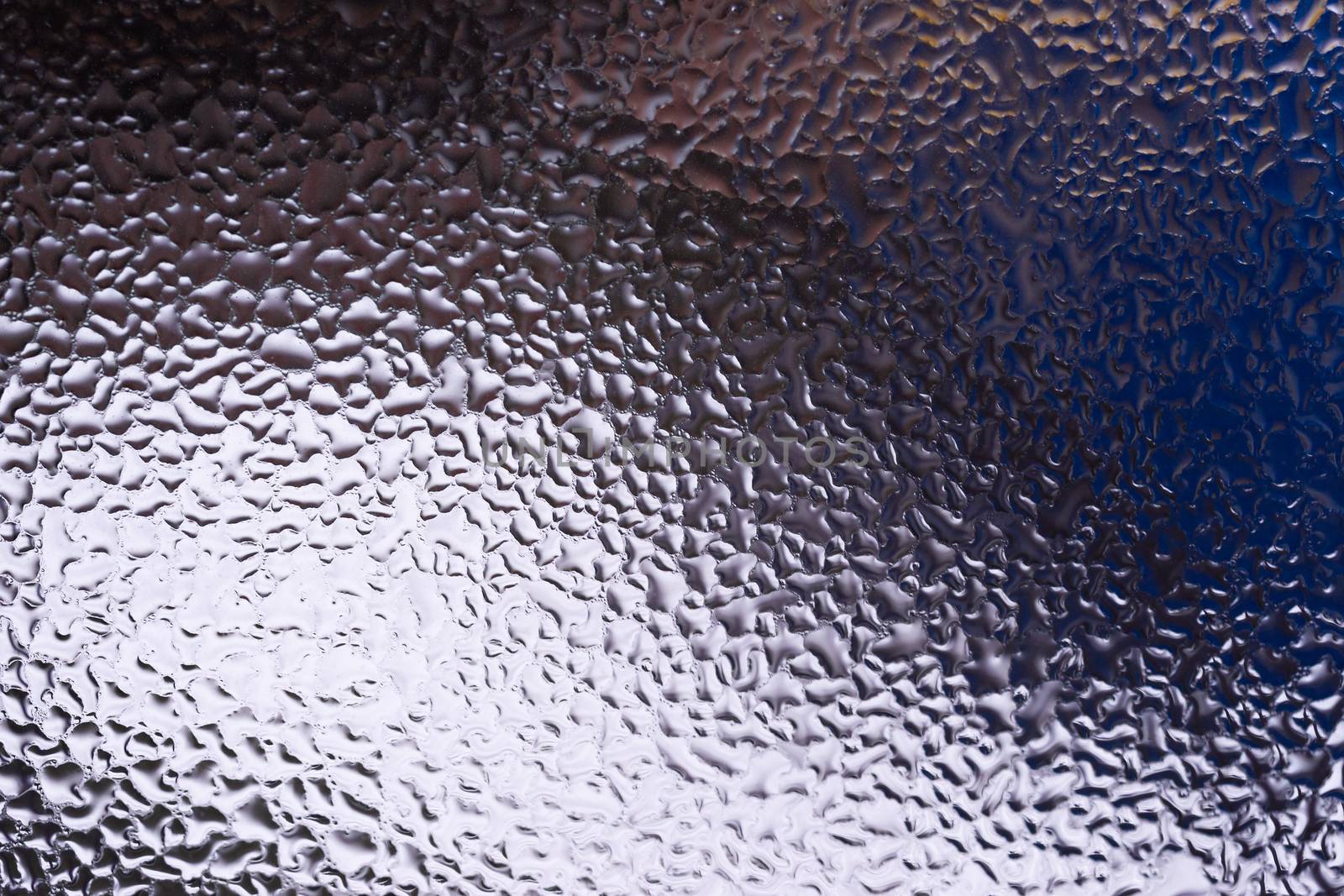 Water drops on glass window close up with blurred background. Drops in macro. Condensate on window closeup. Wet air.