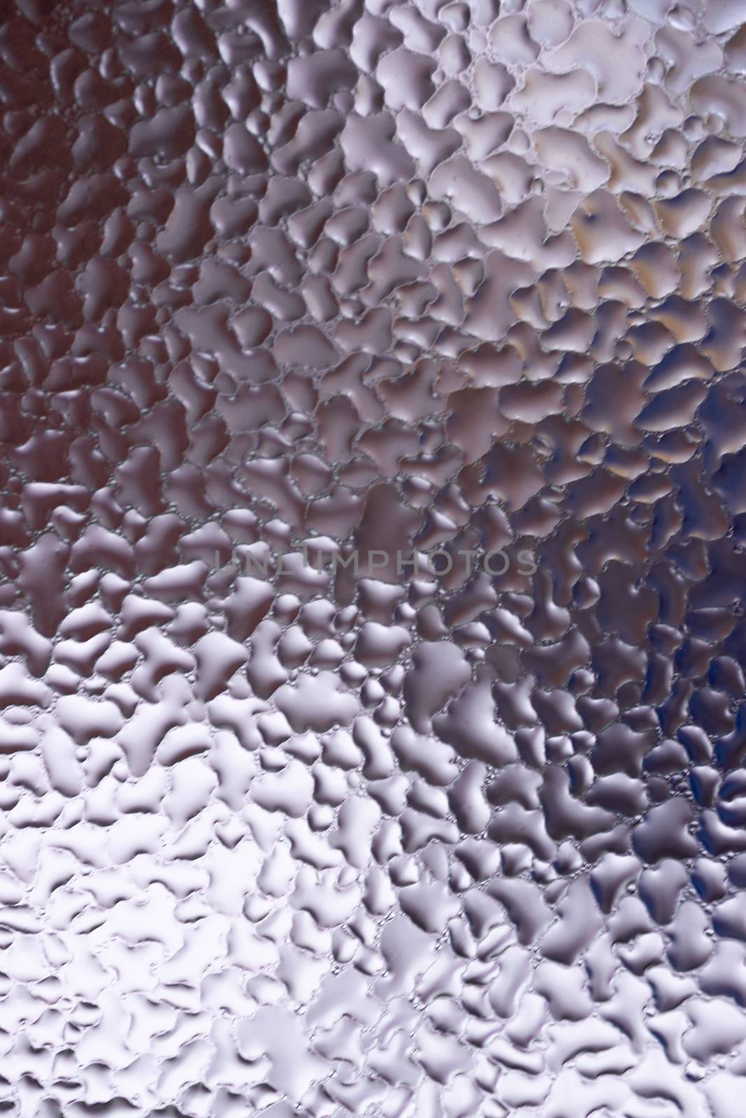 Water drops on glass window close up with blurred background. Drops in macro. Condensate on window closeup. Wet air.