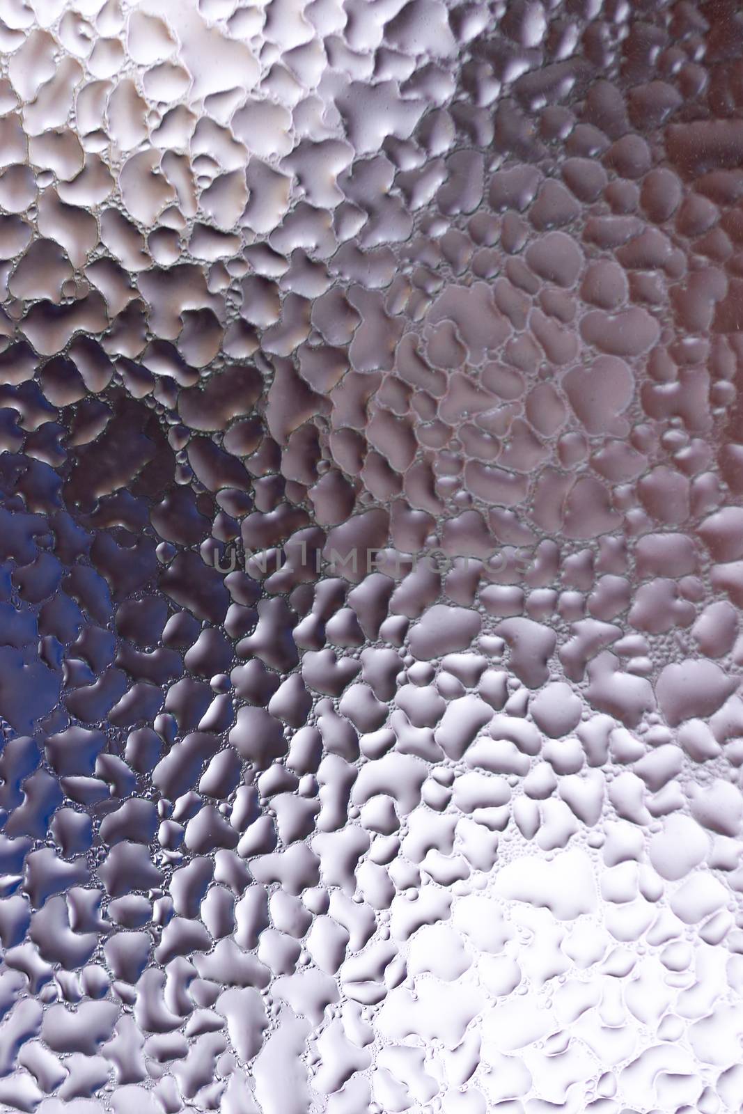 Water drops on glass window close up with blurred background. Drops in macro. Condensate on window closeup. Wet air.