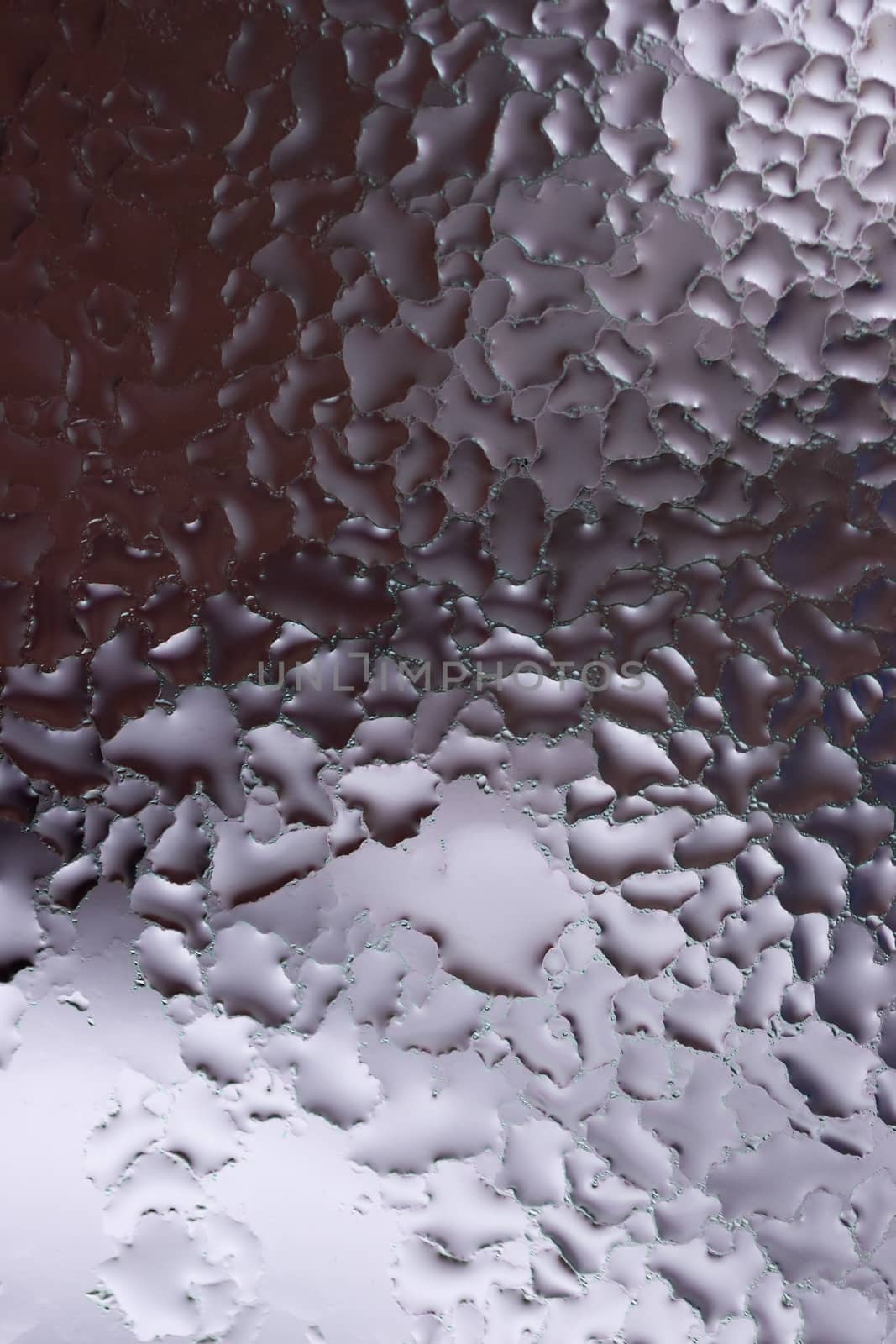 Water drops on glass window close up with blurred background. Drops in macro. Condensate on window closeup. Wet air.