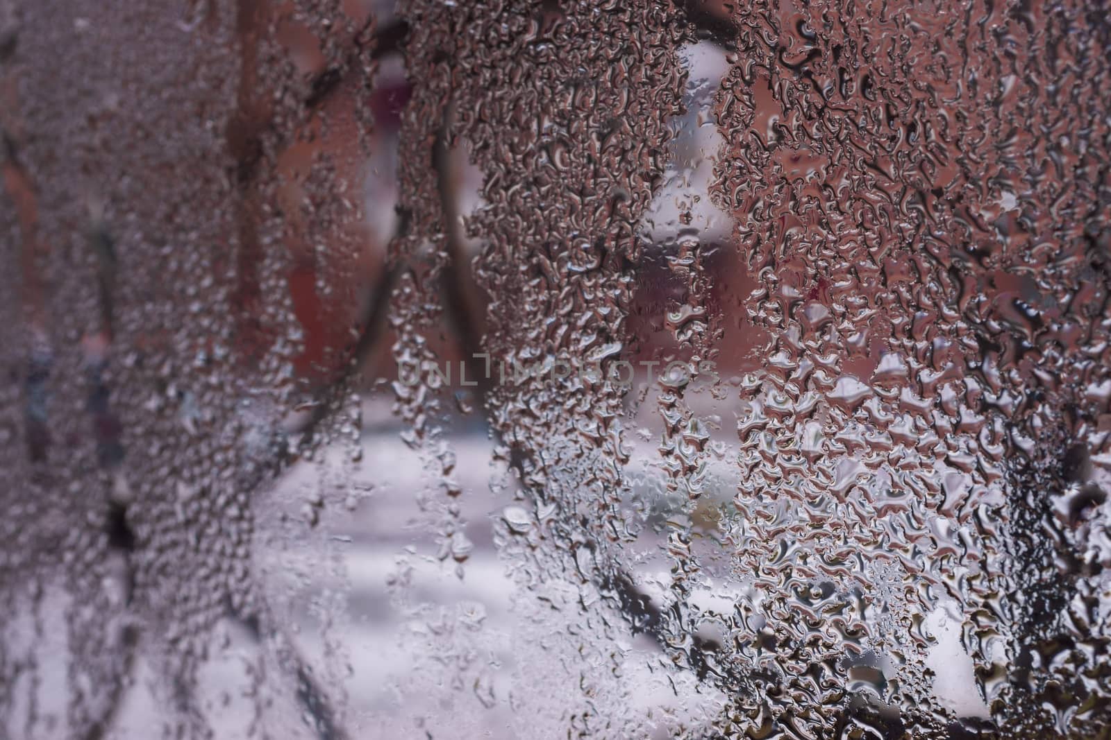 Water drops on glass window close up with blurred background. Drops in macro. Condensate on window closeup. Wet air.