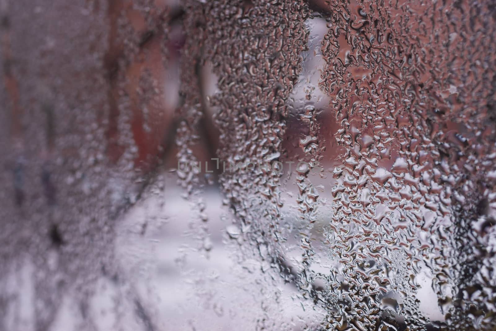 Water drops on glass window close up with blurred background. Drops in macro. Condensate on window closeup. Wet air.