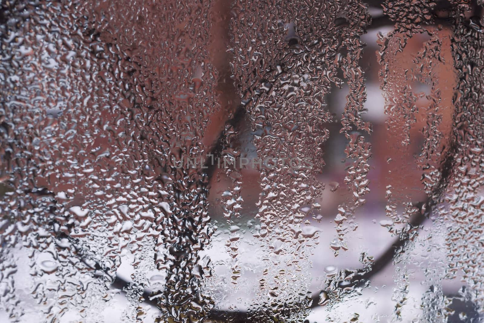 Water drops on glass window close up with blurred background. Drops in macro. Condensate on window closeup. Wet air.