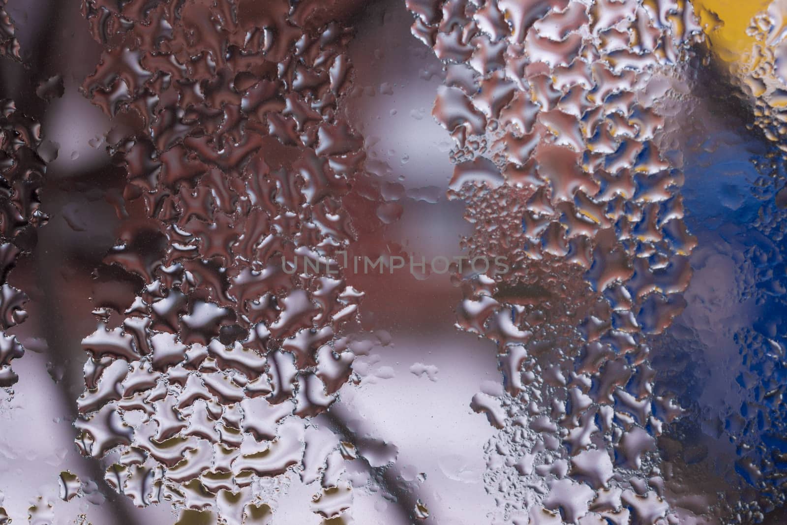Water drops on glass window close up with blurred background. Drops in macro. Condensate on window closeup. Wet air.