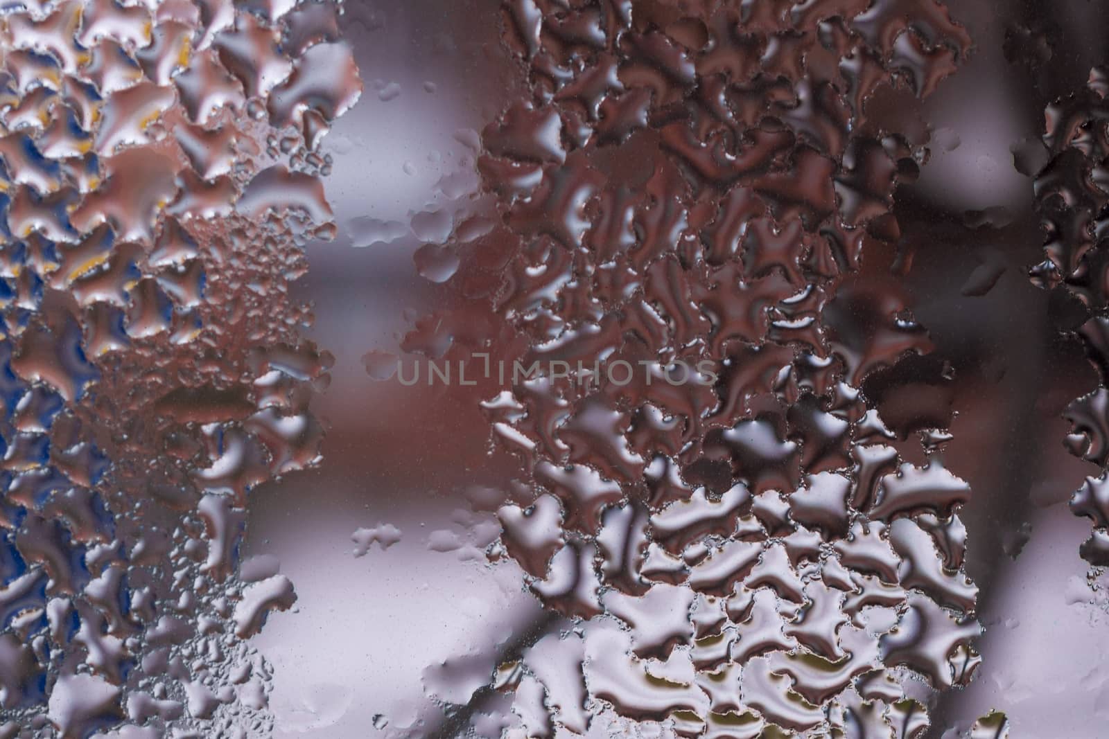 Water drops on glass window close up with blurred background. Drops in macro. Condensate on window closeup. Wet air.