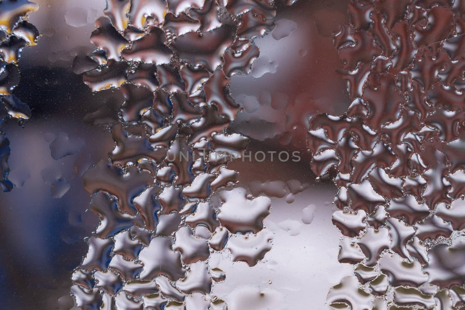 Water drops on glass window close up with blurred background. Drops in macro. Condensate on window closeup. Wet air.
