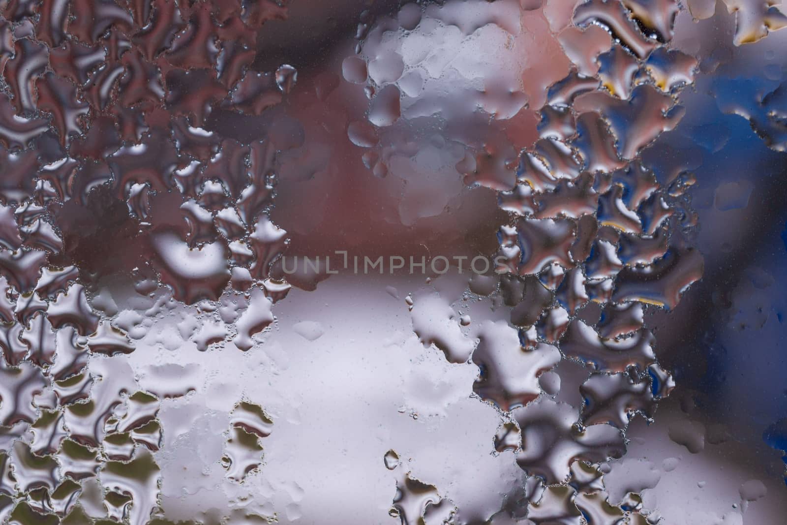 Water drops on glass window close up with blurred background. Drops in macro. Condensate on window closeup. Wet air.