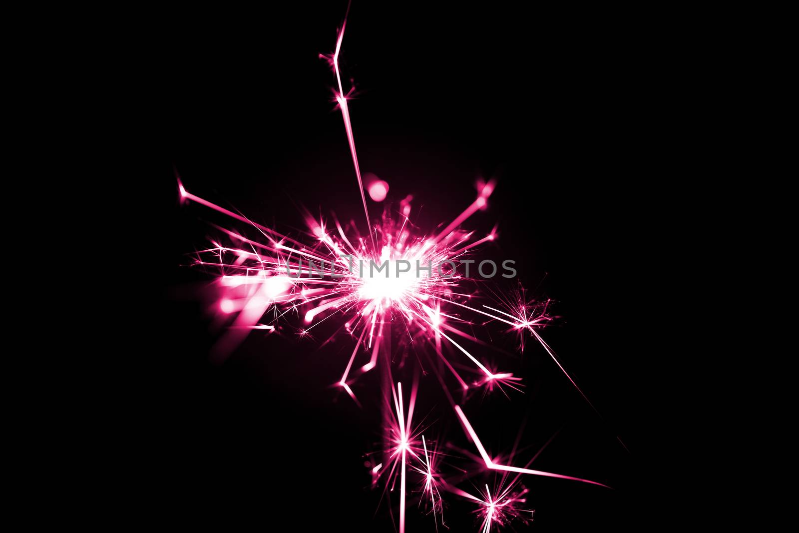 Low light photo of bengali fire isolated on black background with purple toning. A lot of light and sparks. Underexposed photo.